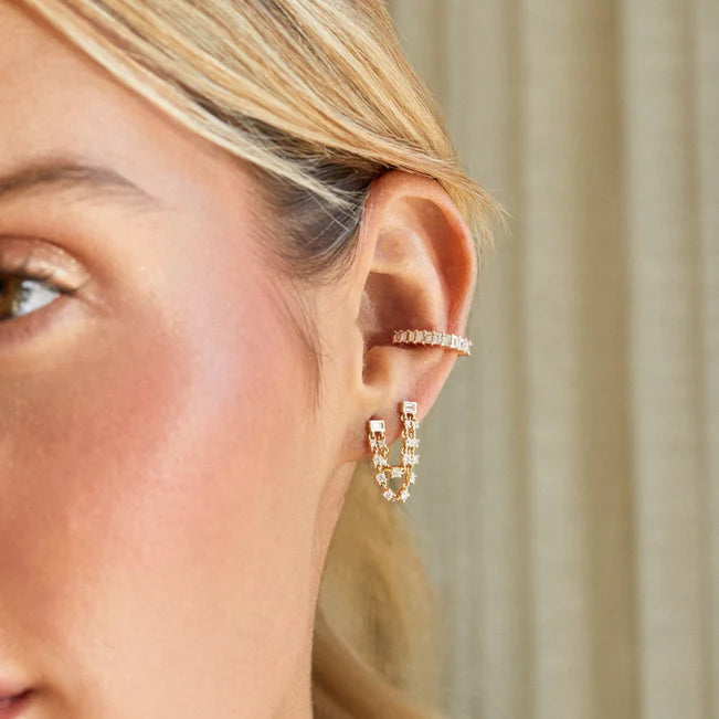Close up of EF Collection Baguette Double Diamond Chain Stud Earring in yellow gold  on models ear. 