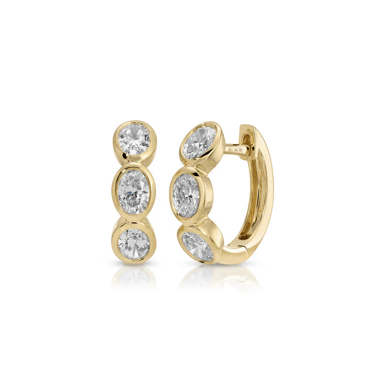 EF Collection Bezel Set Oval Diamond Huggie Earrings in yellow gold on white background