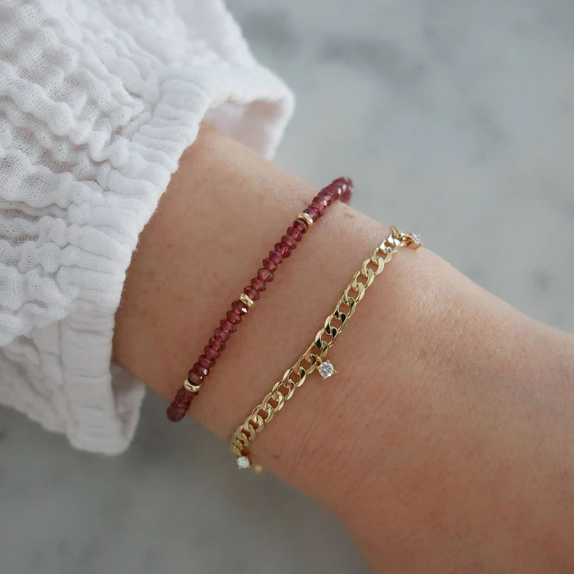 EF-Collection Birthstone Bead Bracelet In Garnet in yellow gold on models wrist with chain bracelet 