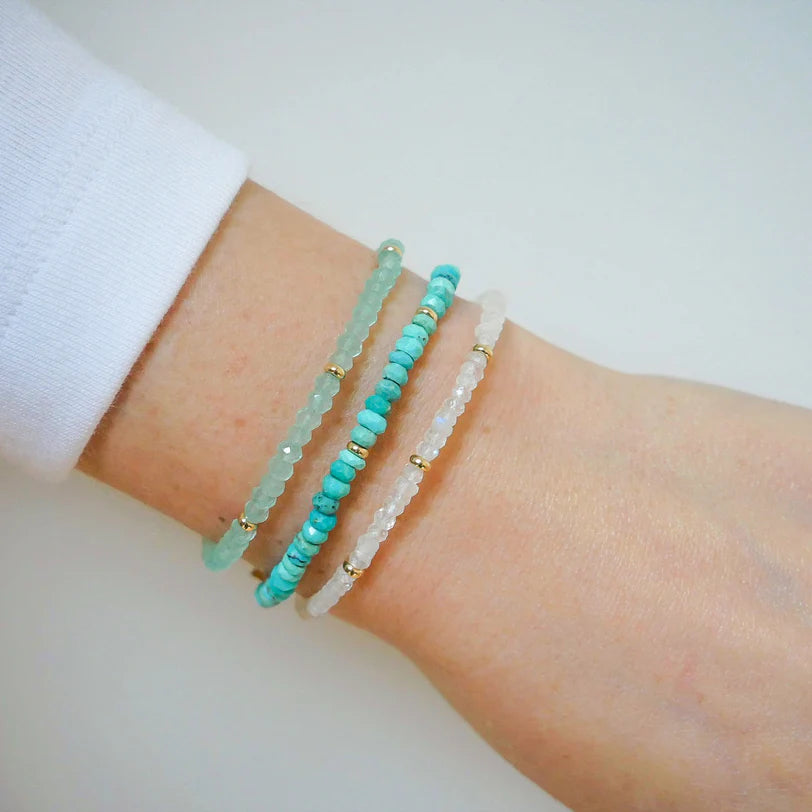 EF-Collection Birthstone Bead Bracelet In Turquoise in yellow gold styled on models wrist with other bead bracelets 