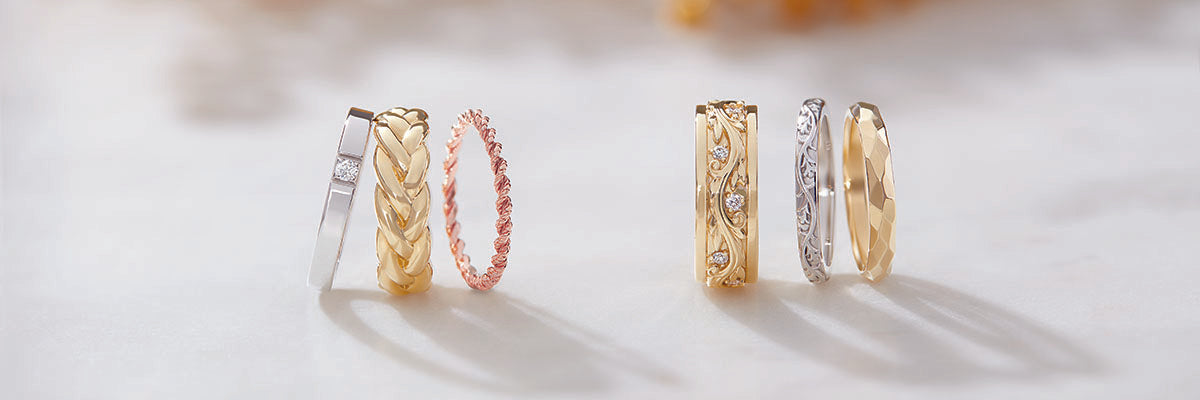 Set of gold wedding band rings on a light background