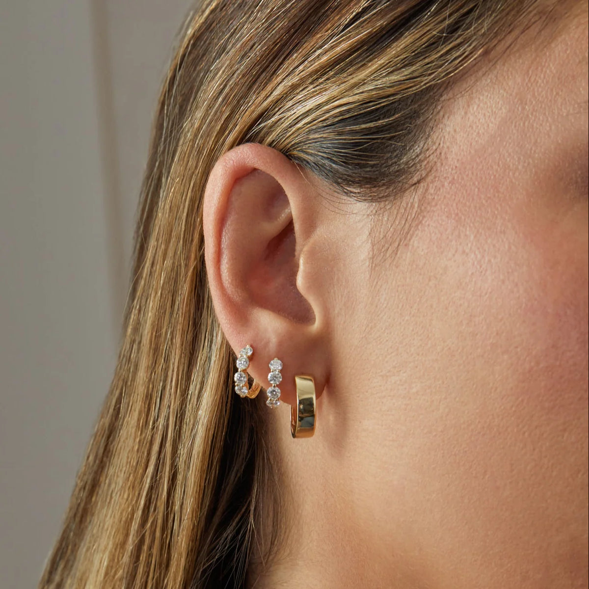 EF-Collection Charlie Hoop Earrings in yellow gold styled on models ear with diamond huggies 