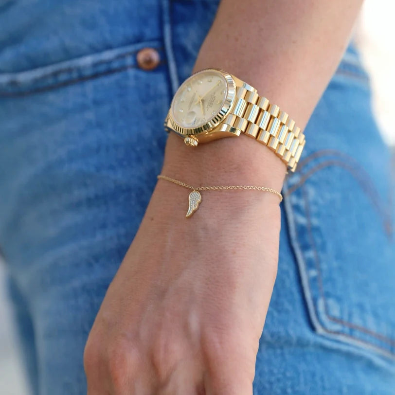 EF Collection Diamond Angel Wing Bracelet in yellow gold styled on models wrist with a yellow gold watch