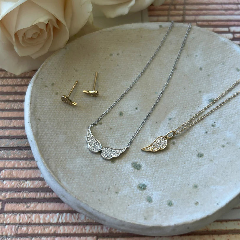 EF Collection Diamond Angel Wing Necklace in yellow gold with double angel wings necklace and angel wing earrings in a small plate. 