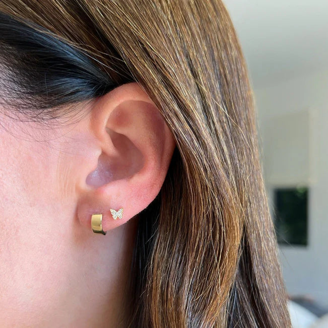 EF Collection Diamond Baby Butterfly Stud Earring in yellow gold on models ear styled with a gold huggie. 