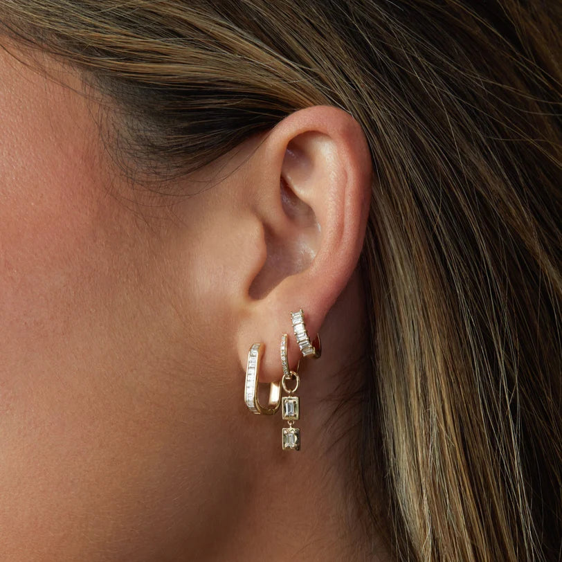 Ef collection close up of Diamond Baguette Jumbo Lola Huggie Earring in yellow gold on models ear styled with different hoops.