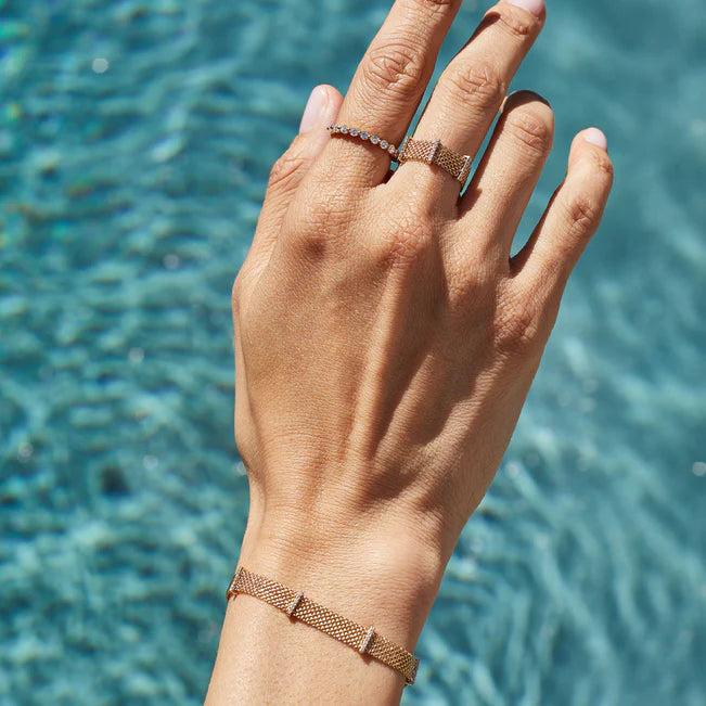 EF Collection Diamond Bar Mesh Bracelet in rose gold on models wrist with pool background. 