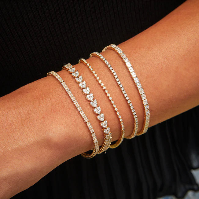 EF Collection Diamond Bezel Eternity Bracelet in yellow gold on models wrist with four eternity bracelets. 
