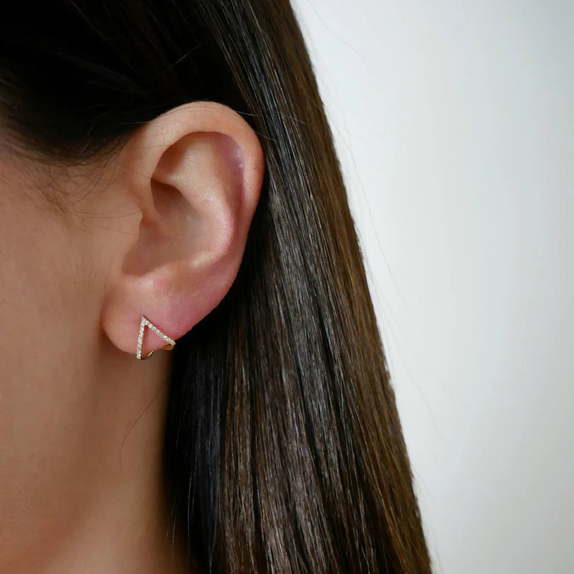 Single EF Collection Diamond Chevron Huggie Earrings in yellow gold styled on models ear. 
