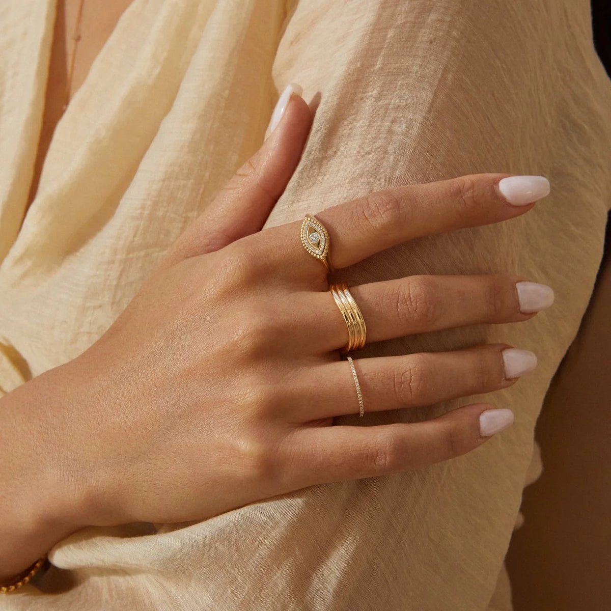EF-Collection Diamond Eternity Band Ring in yellow gold stacked on models finger with other rings