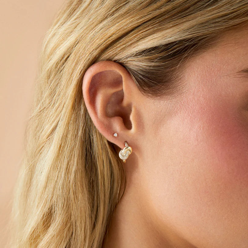 EF Collection Diamond & Gold Love Knot Stud Earrings in yellow gold styled on models ear. 