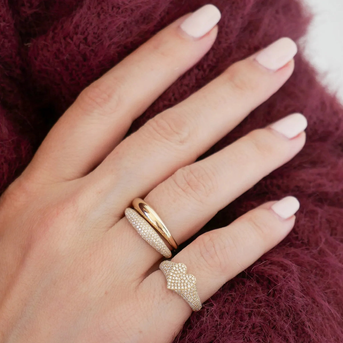 Product shot of EF-Collection Diamond Heart Signet Ring in yellow gold styled on models hand wearing a wine colored sweater 