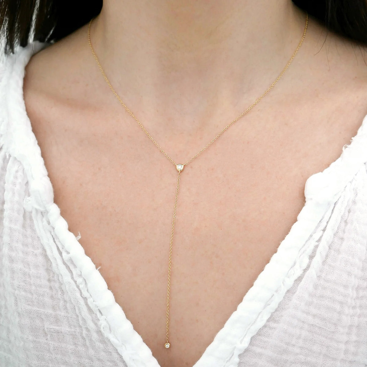 Close up of EF-Collection Diamond Pillow Lariat Necklace in yellow gold styled on models neck
