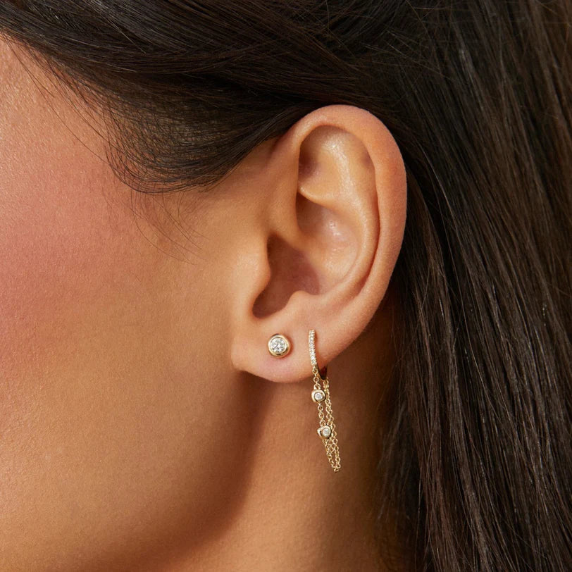 Single EF Collection Diamond Pillow Stud Earrings in yellow gold on models ear layered with chain huggie. 