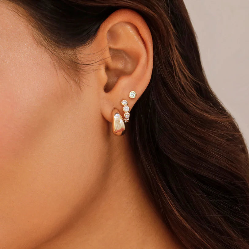 EF Collection Diamond Pillow Stud Earrings in yellow gold on models ear with diamond and gold hoops. 