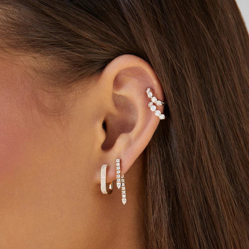EF-Collection Diamond Teardrop Fringe Earring in yellow gold displayed on models ears stacked with different hoops. 