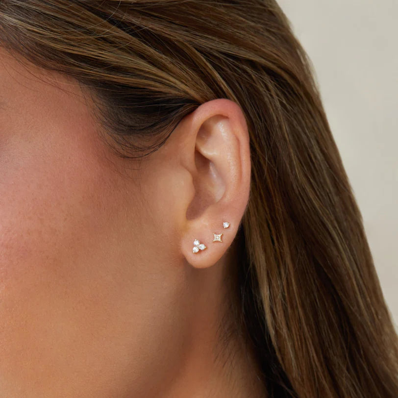 EF Collection Diamond Trio Stud Earring in yellow gold stacked on models ear with studs. 