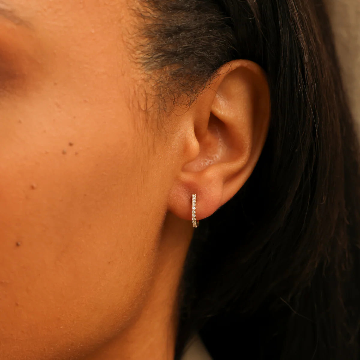 Single Dana Rebecca Designs DRD Medium Huggies in yellow gold on models ear 