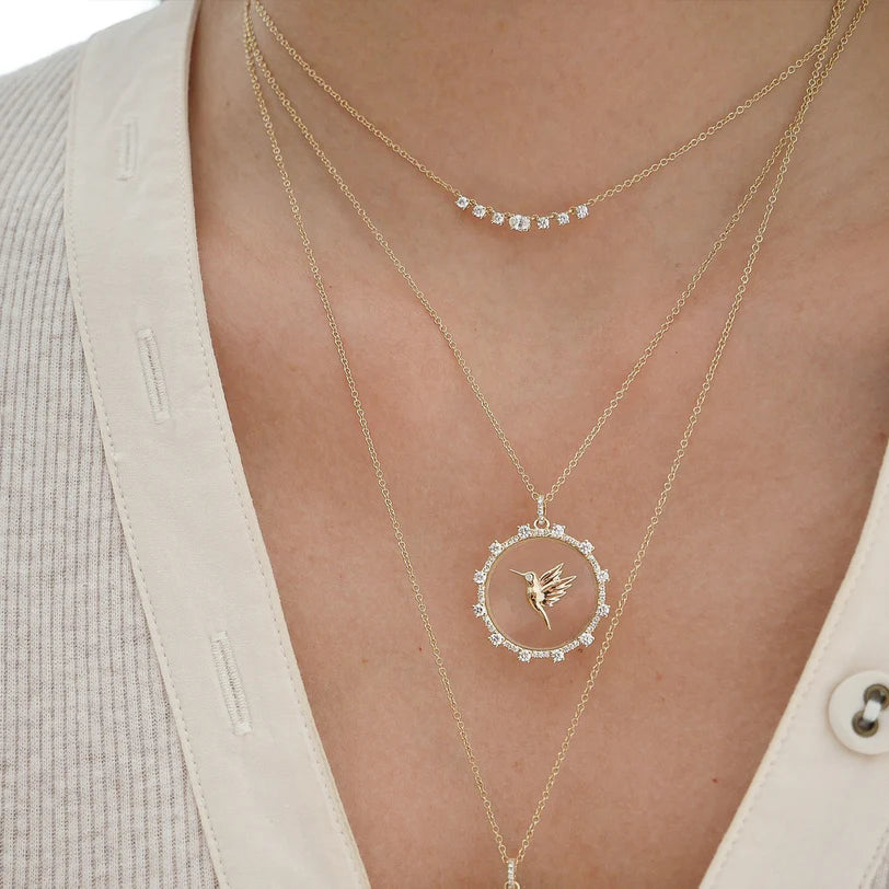 Close up of EF Collection Floating Hummingbird Necklace in yellow gold styled on models neck 