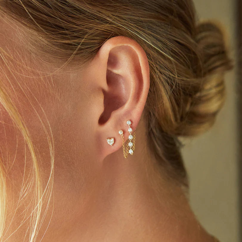 Single EF Collection Full Cut Diamond Mini Heart Stud Earring in yellow gold styled on models ear. 