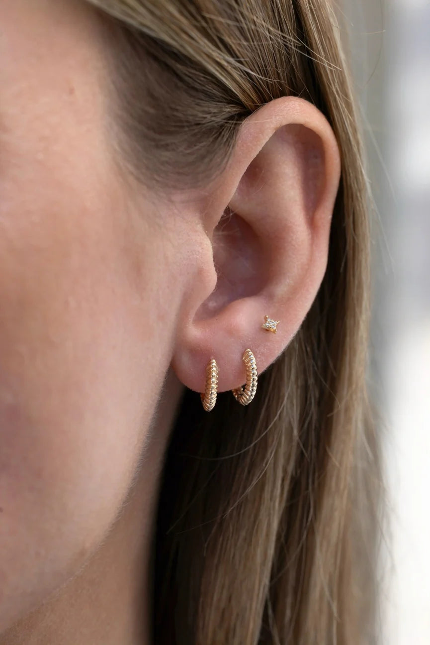 EF-Collection Gold Fluted Knife Edge Mini Huggie Earrings in yellow gold styled on models ear with a diamond stud 