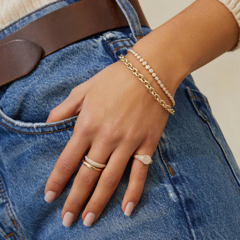 Product shot of EF-Collection Graduated Diamond Pillow Tennis Bracelet in yellow gold on models wrist with chain bracelet 