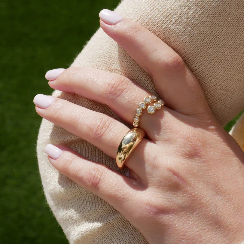 EF Collection Graduated Diamond Pillow Wrap Ring in yellow gold on model’s finger layered with gold ring. 