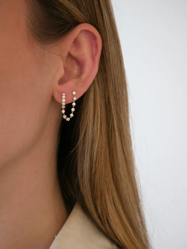 Single EF Collection Jumbo Diamond Mini Huggie and Prong Set Chain Stud Earring in yellow gold on models ear. 