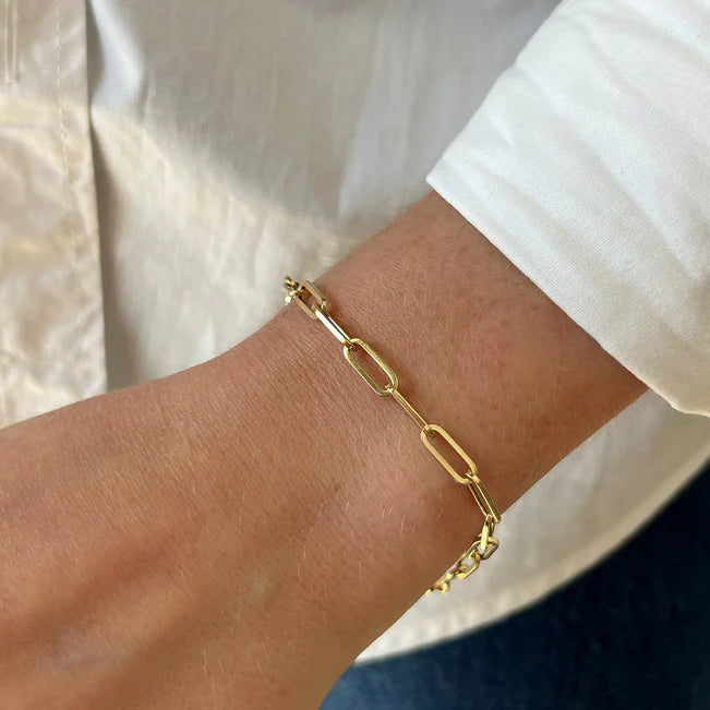 EF Collection Jumbo Lola Chain Bracelet in yellow gold styled on models wrist with white shirt. 