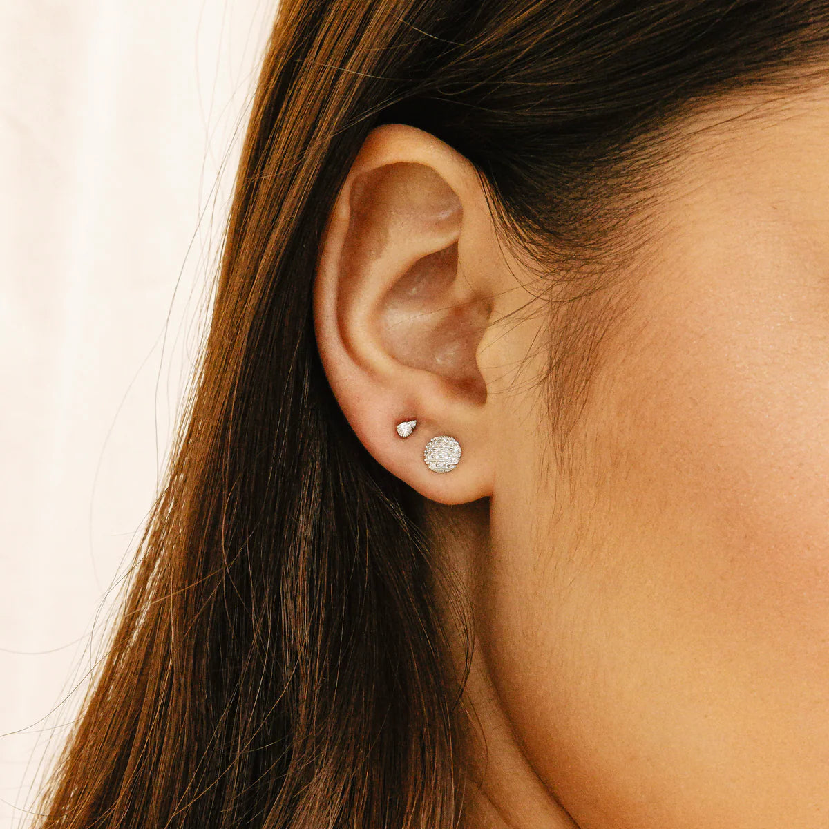 close up of Lauren Joy Mini Disc Studs in Yellow Gold styled with other piercings on ear