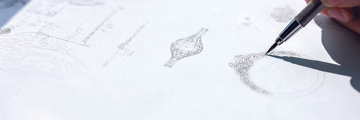 Hand holding a pen over a white surface with jewelry drawings.