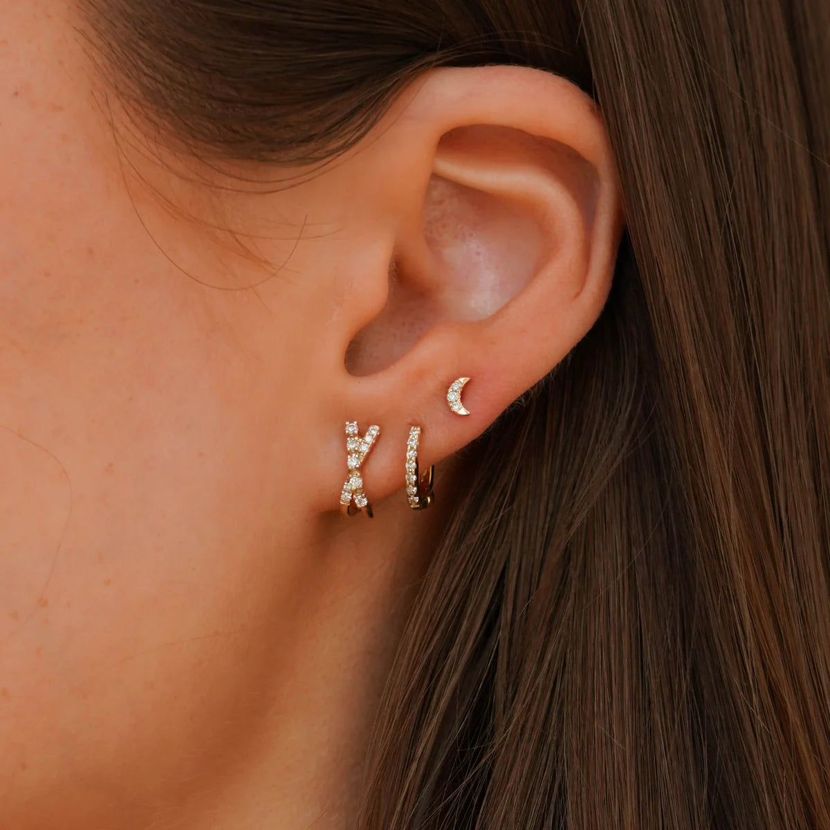 close up of Dana Rebecca Designs mini crescent moon stud earrings in yellow gold on an ear