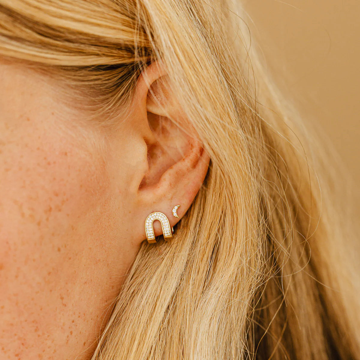 close up of Dana Rebecca Designs mini crescent moon stud earrings in white gold styled with a hoop