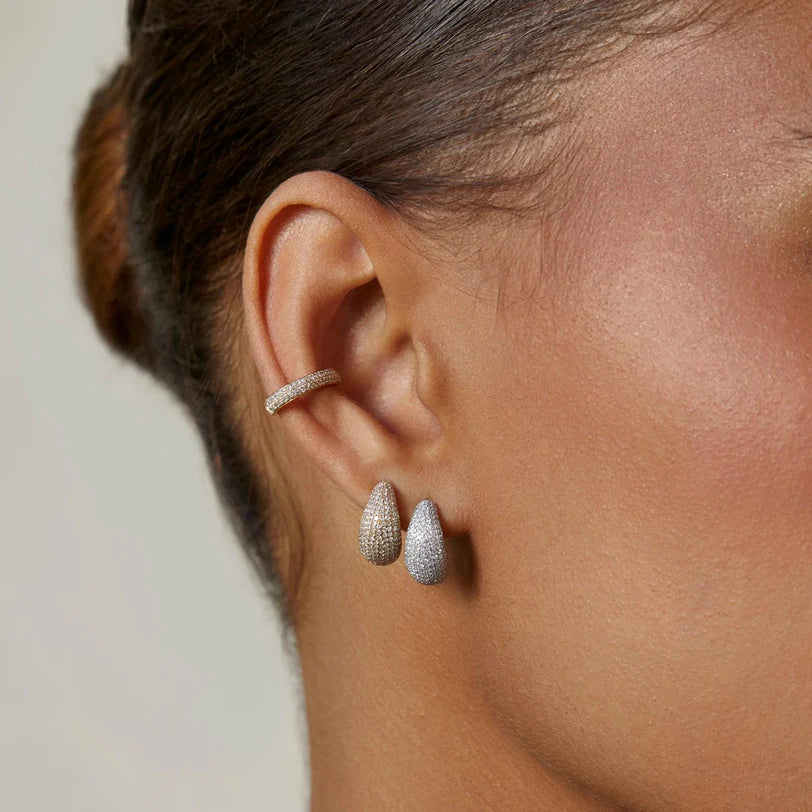 EF Collection Pavé Diamond Jumbo Dome Huggie Earrings in yellow gold and white gold styled on models ear. 