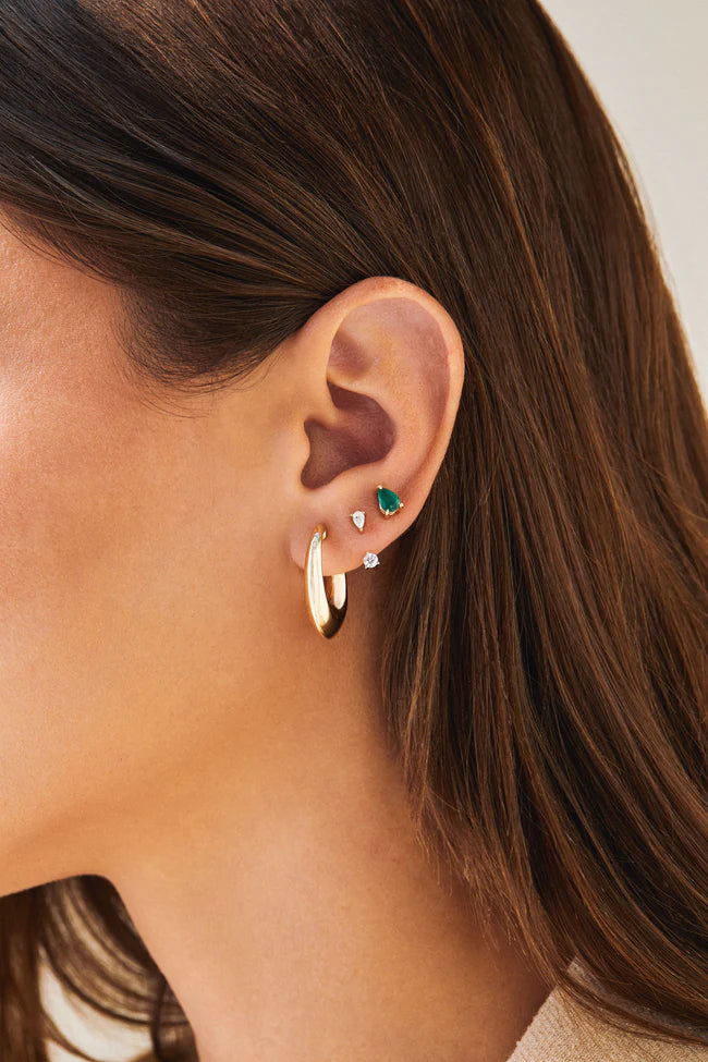 EF Collection Pear Emerald Stud Earrings in yellow gold styled on models ear. 