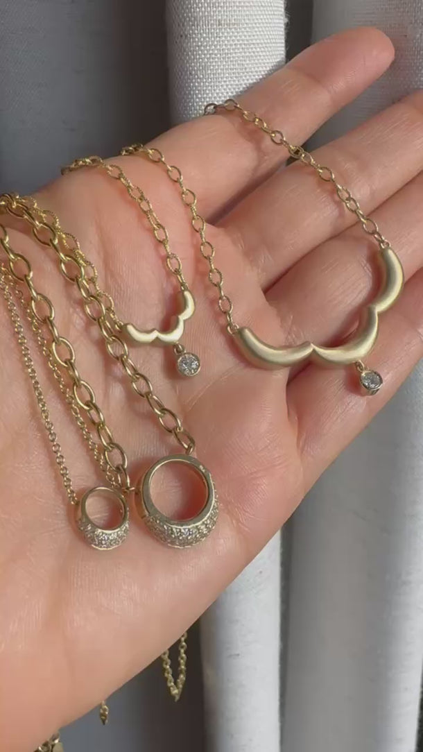 Close up video of Onirikka Midi Floret Necklace in satin 14k yellow gold with a diamond pendant on an 18-inch rolo chain.