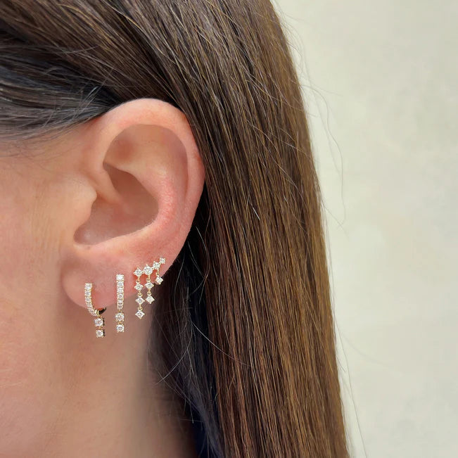 EF Collection Prong Set Diamond Double Drop Mini Huggie Earring in yellow gold layered on models ear. 