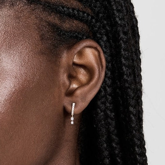 Single EF Collection Prong Set Diamond Double Drop Mini Huggie Earring in yellow gold models ear. 
