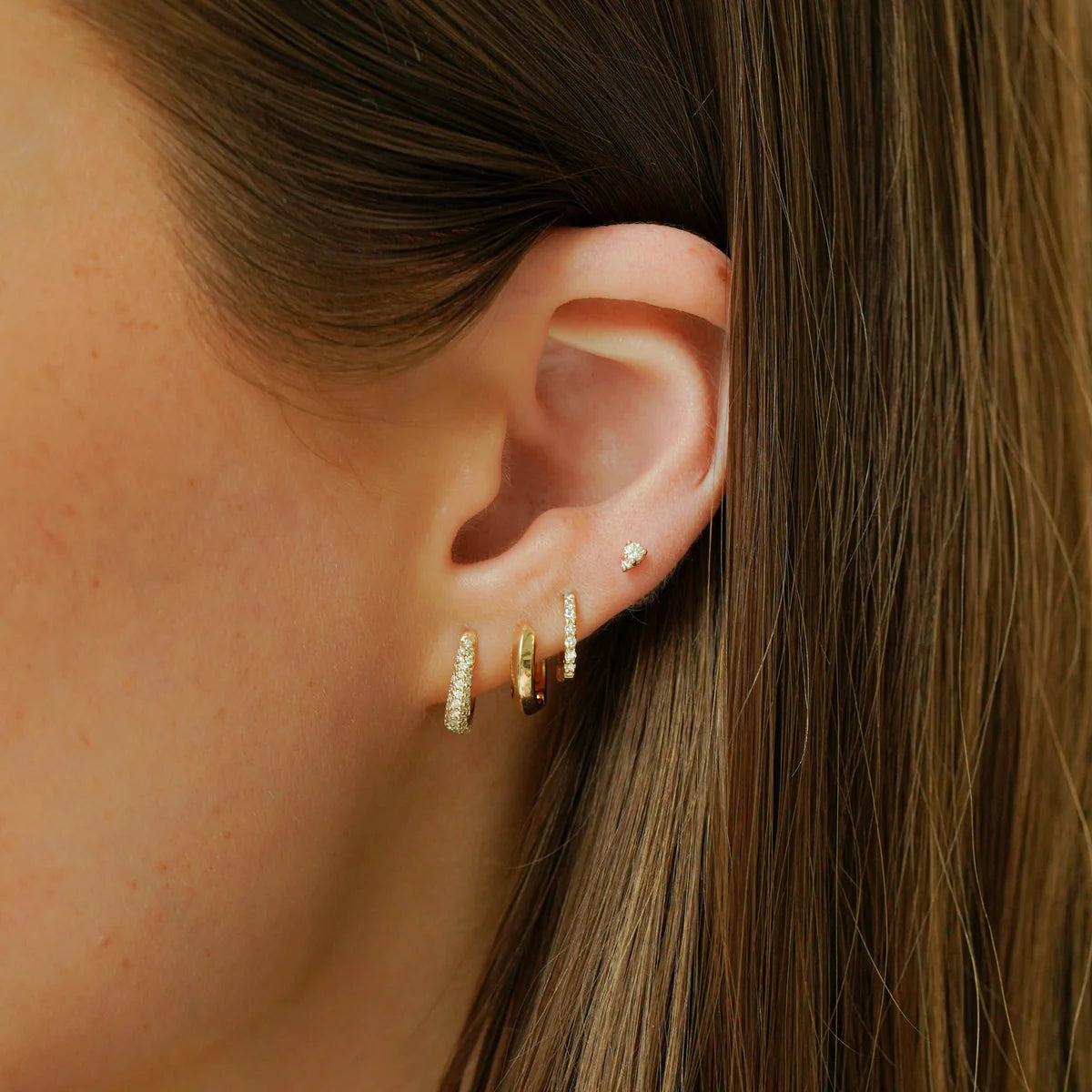 close up of Dana Rebecca Designs Sophia Ryan Petite Teardrop studs in yellow gold stacked with other DRD huggies
