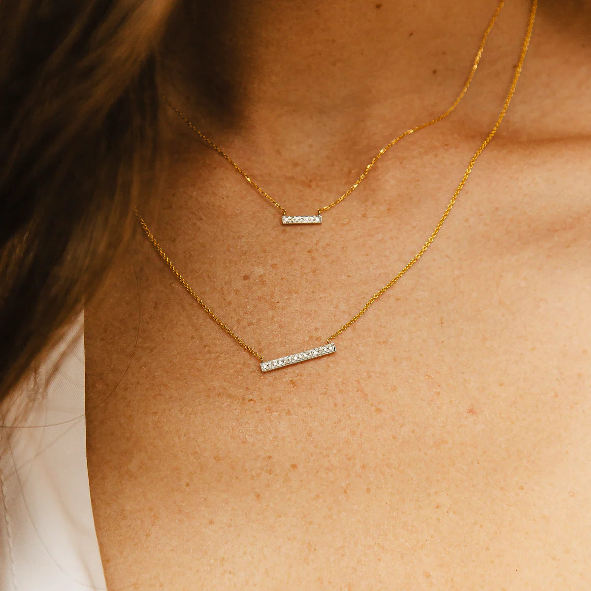 close up of Dana Rebecca Designs Sylvie Rose 14K Yellow Gold Medium Bar Necklace layered with mini bar necklae