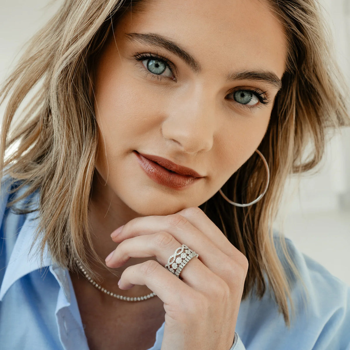Dana Rebecca Designs Taylor Beth Eternity Band Ring in white gold styled on models finger wearing a light blue shirt 