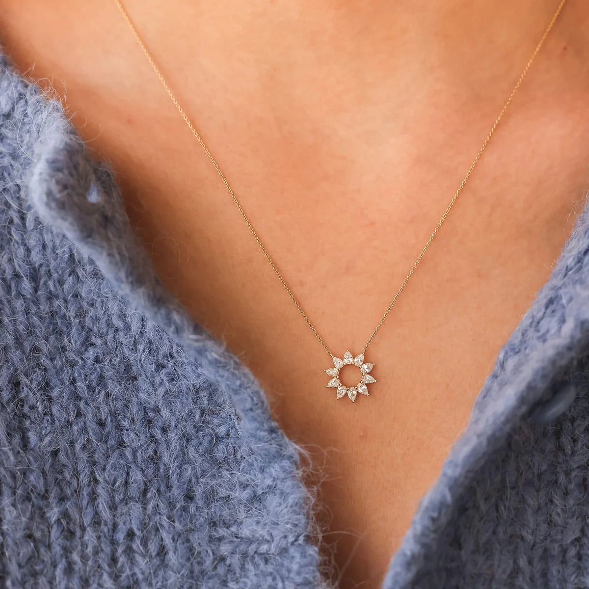 Dana Rebecca Designs Taylor Elaine Pear Flower Necklace in yellow gold styled on model with blue knitted blouse. 