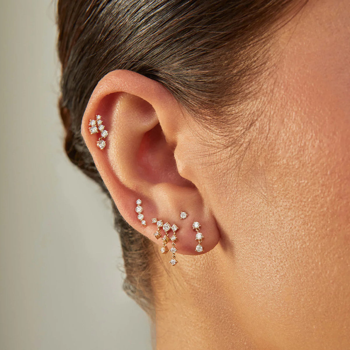 EF-Collection Triple Prong Set Diamond Stud Earrings in yellow gold styled on models ear with earrings from the same collection 