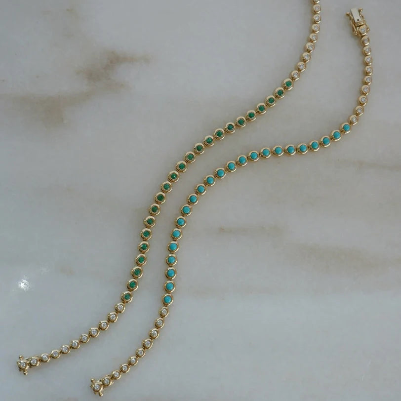 EF Collection Turquoise & Diamond Pillow Eternity Bracelet and Emerald & Diamond Pillow Eternity Bracelet  in yellow gold on marble background. 